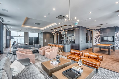 a living room with couches and chairs and a pool table